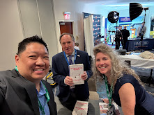 Ron at a trade show with readers holding his book